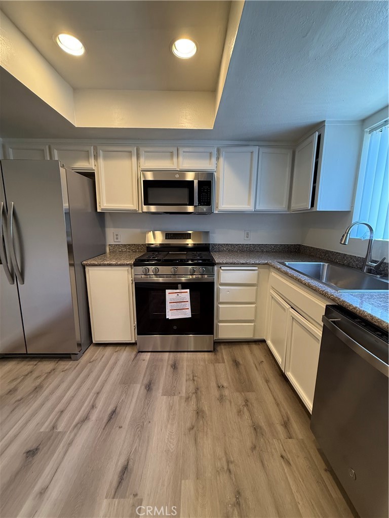 5250 Colodny Drive, Unit 17 Agoura Hills, CA 91301 - Photo 6 of 17 a kitchen with stainless steel appliances granite countertop a stove top oven a sink and a microwave