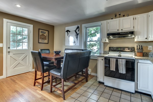 3 1/2 Becket Avenue, Unit 3 Salem, MA 01970 - Photo 4 of 22 a kitchen with stainless steel appliances granite countertop a stove a sink a dining table and chairs with wooden floor