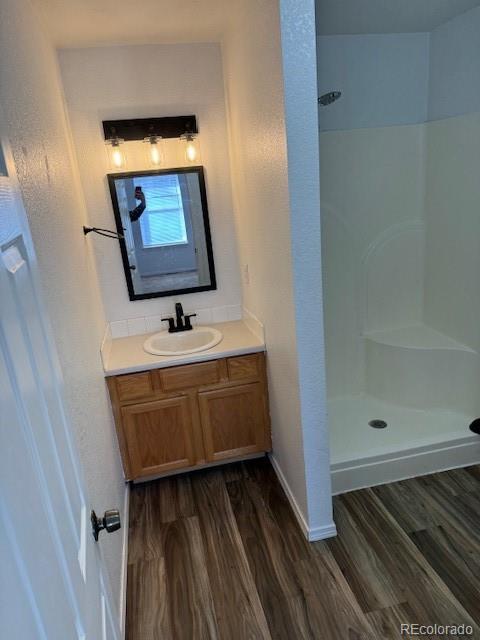 304 Sunset Lane Dacono, CO 80514 - Photo 7 of 22 a bathroom with a sink a mirror and shower