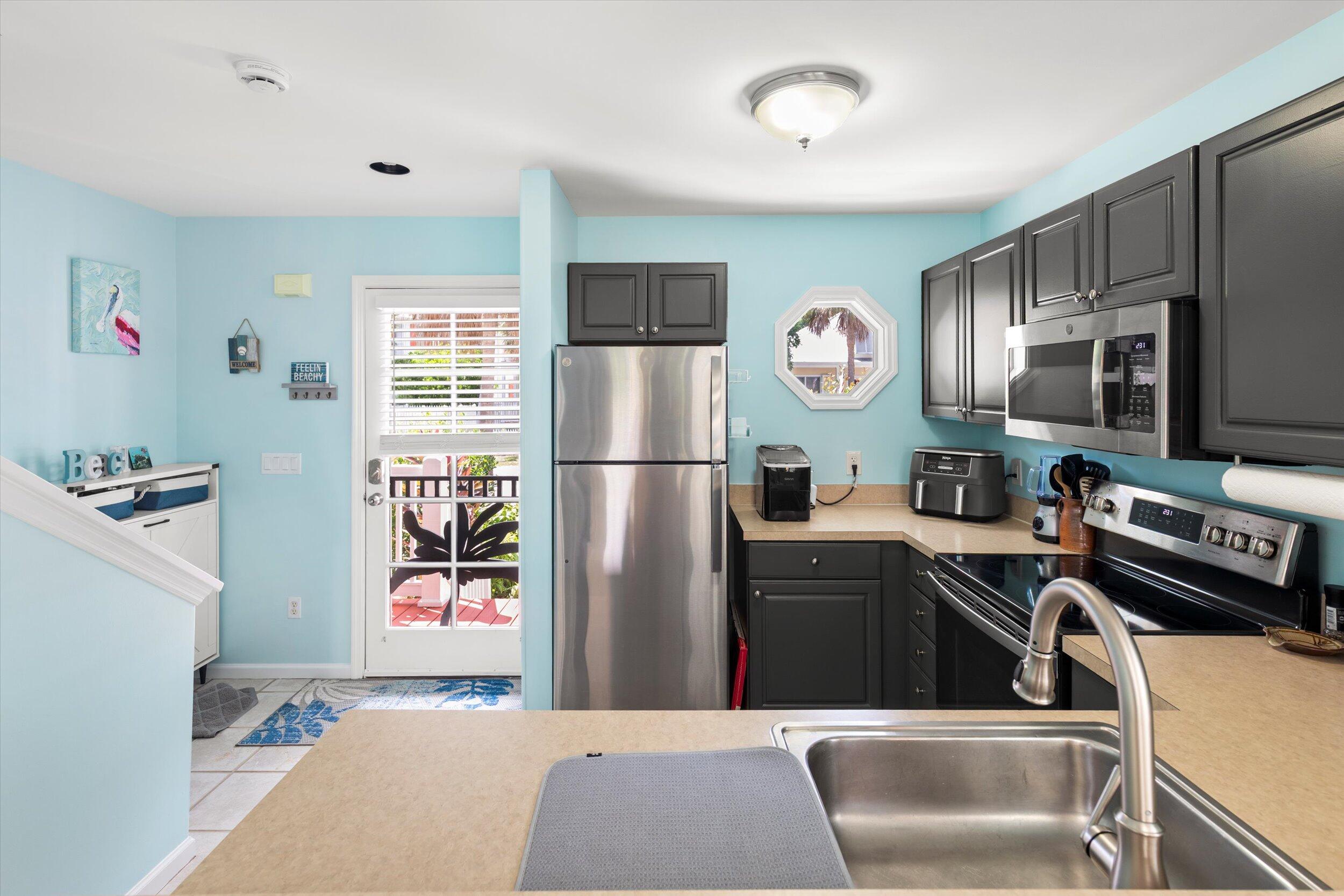 45 Spoonbill Way Key West, FL 33040 - Photo 26 of 80 a kitchen with stainless steel appliances granite countertop a refrigerator a stove a sink and a microwave