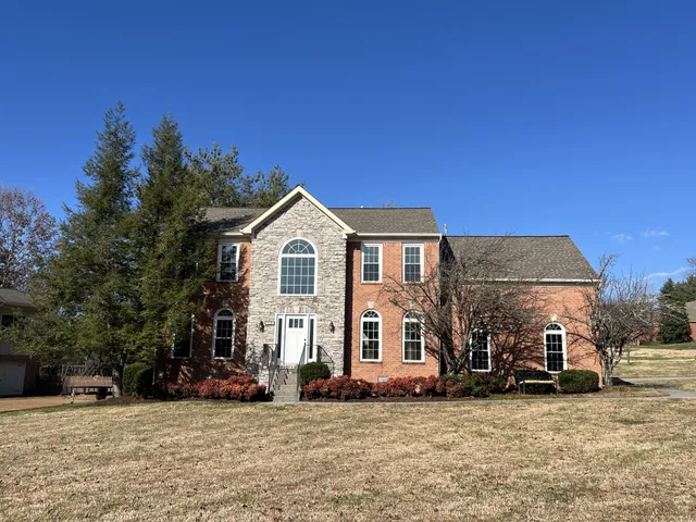 a view of a house with a yard and sitting area