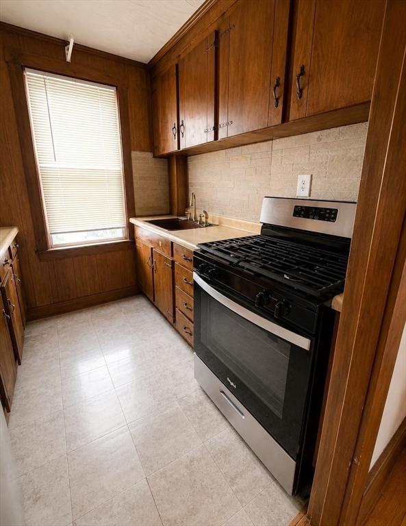 37 Shawmut Street Fall River, MA 02720 - Photo 5 of 16 a kitchen with a stove a sink and a window