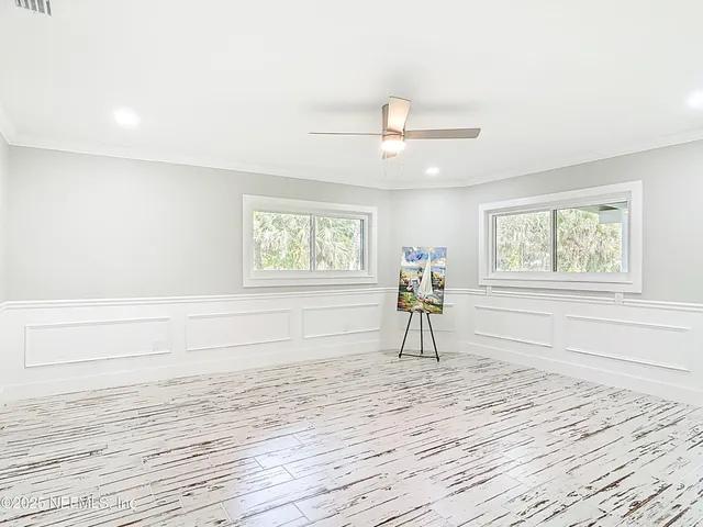 a view of empty room with wooden floor