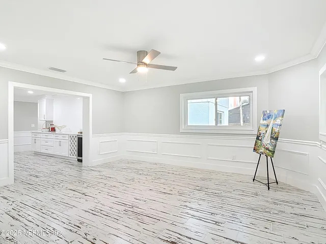 a view of a room with wooden floor and a ceiling fan
