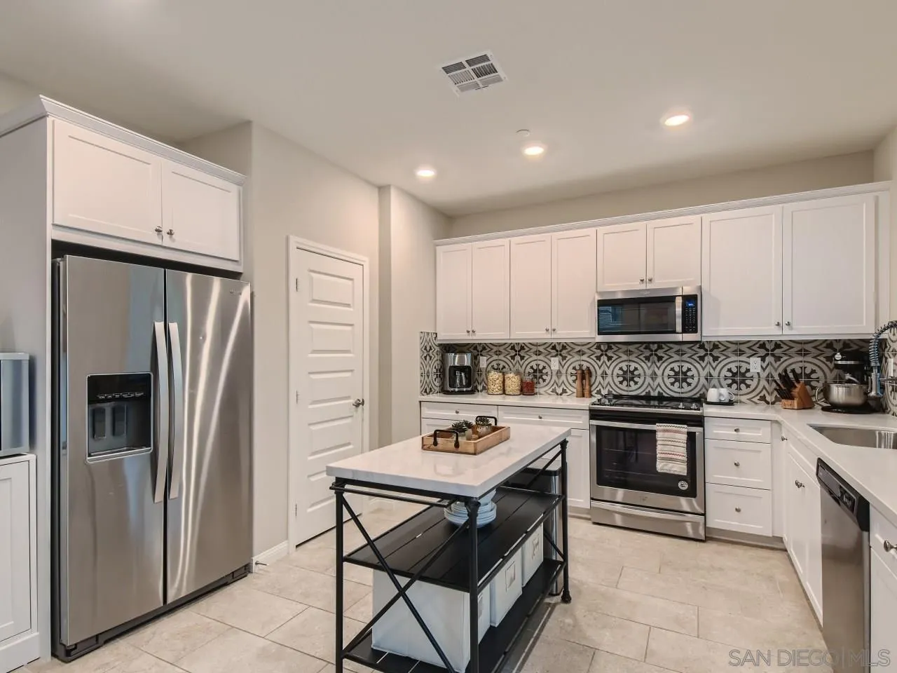 10660 Busch Street Spring Valley, CA 91978 - Photo 9 of 29 a kitchen with stainless steel appliances granite countertop a stove refrigerator sink and cabinets