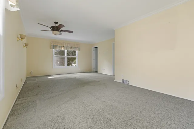 a view of a livingroom with a ceiling fan and window
