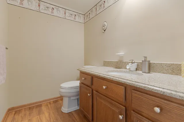 a bathroom with a granite countertop sink a toilet and a shower