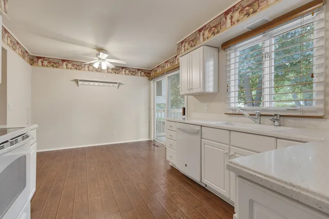 a kitchen with a sink cabinets stainless steel appliances and a large window