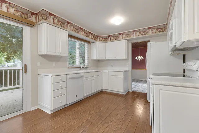 a kitchen with a sink cabinets stainless steel appliances and a window