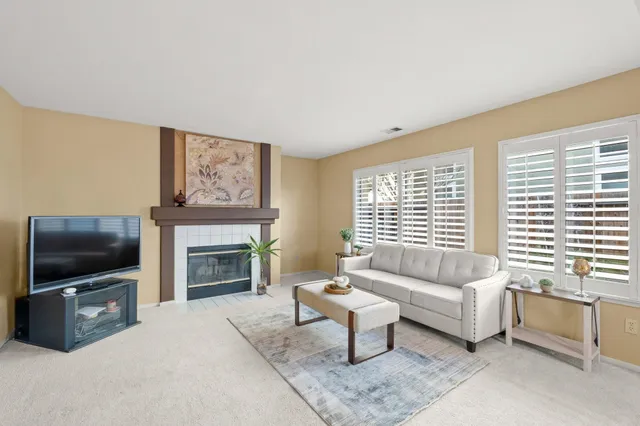 a living room with furniture a flat screen tv and a fireplace