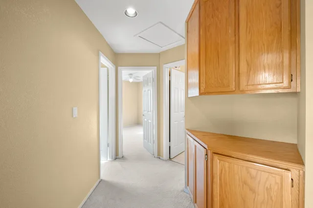 a view of a hallway with wooden floor and cabinet