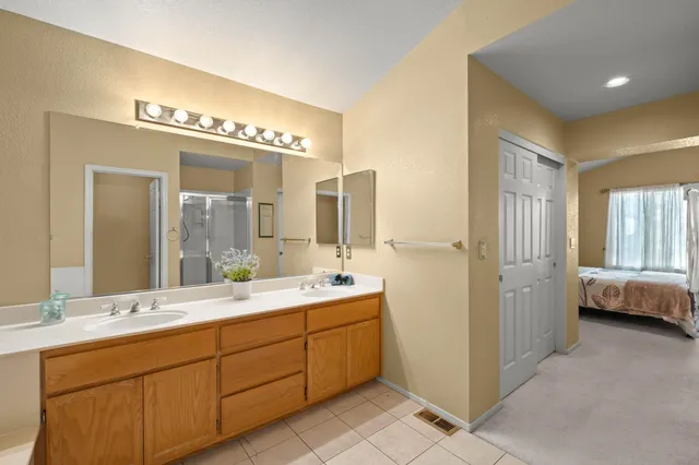a spacious bathroom with a double vanity sink and a mirror