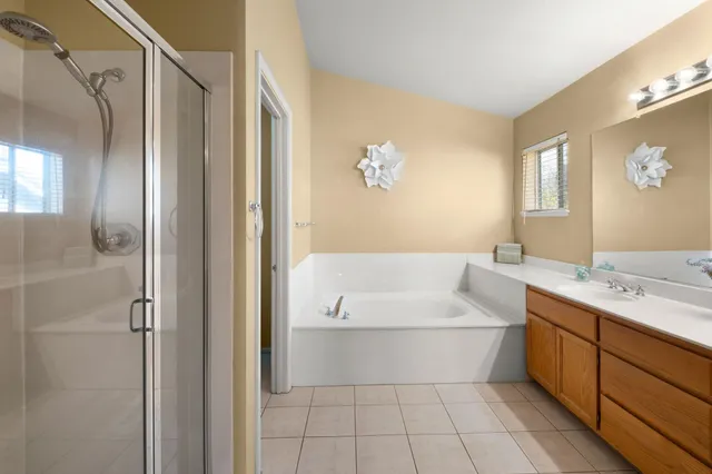 a bathroom with a tub a sink and mirrors