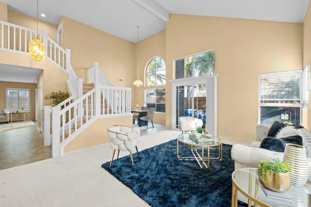 a living room with furniture a dining table and a chandelier