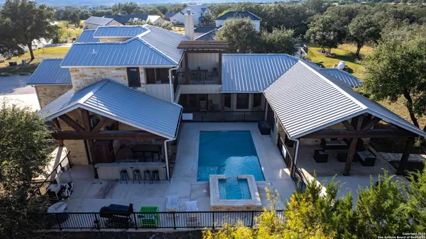 an aerial view of residential houses with outdoor space and trees