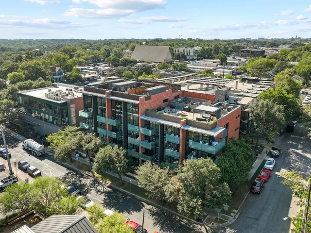 an aerial view of a city with lots of residential buildings ocean and mountain view in back