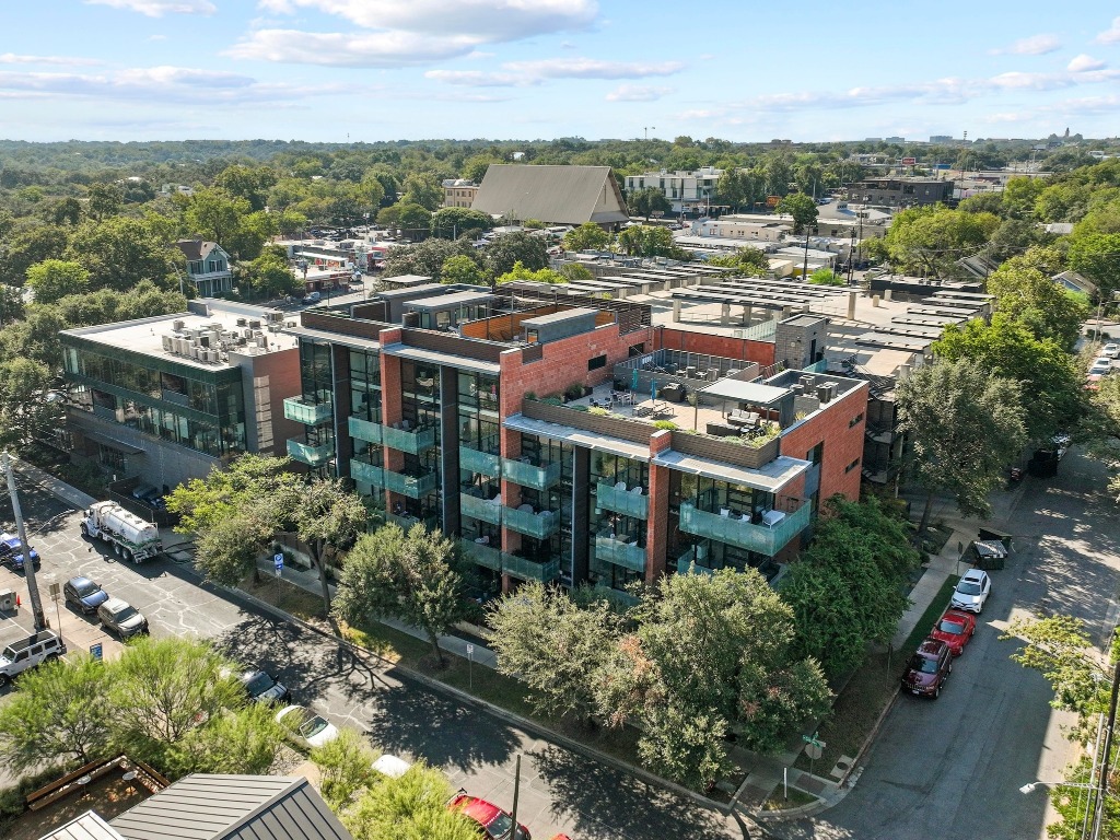 an aerial view of a city with lots of residential buildings ocean and mountain view in back