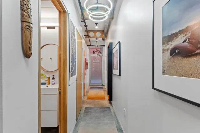 a view of a hallway with windows and chandelier
