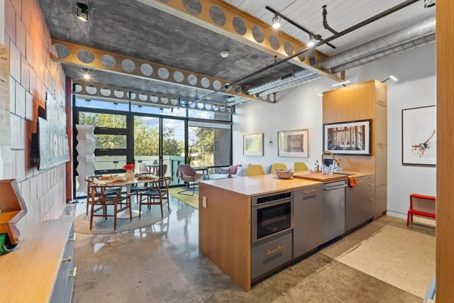 a view of a kitchen with kitchen island granite countertop a stove and a view of living room