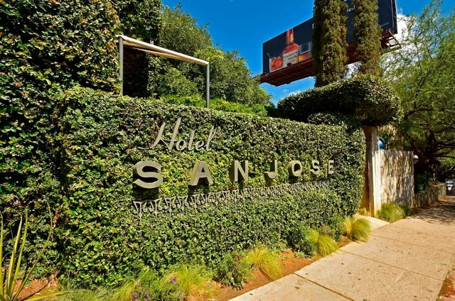 a porch with a bench and potted plants
