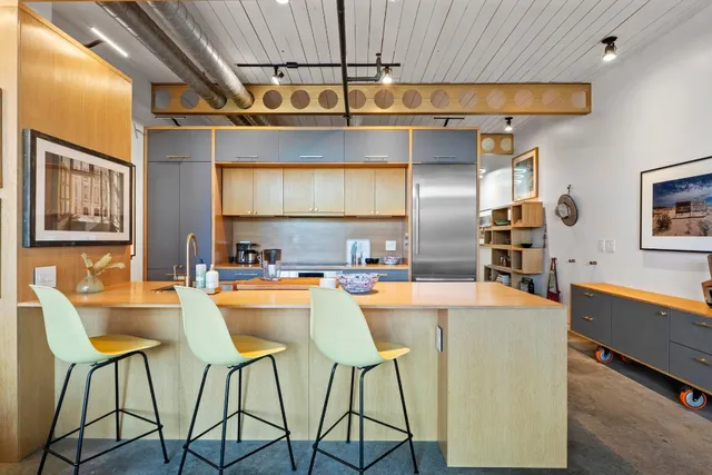 a kitchen with stainless steel appliances kitchen island a large window and cabinets