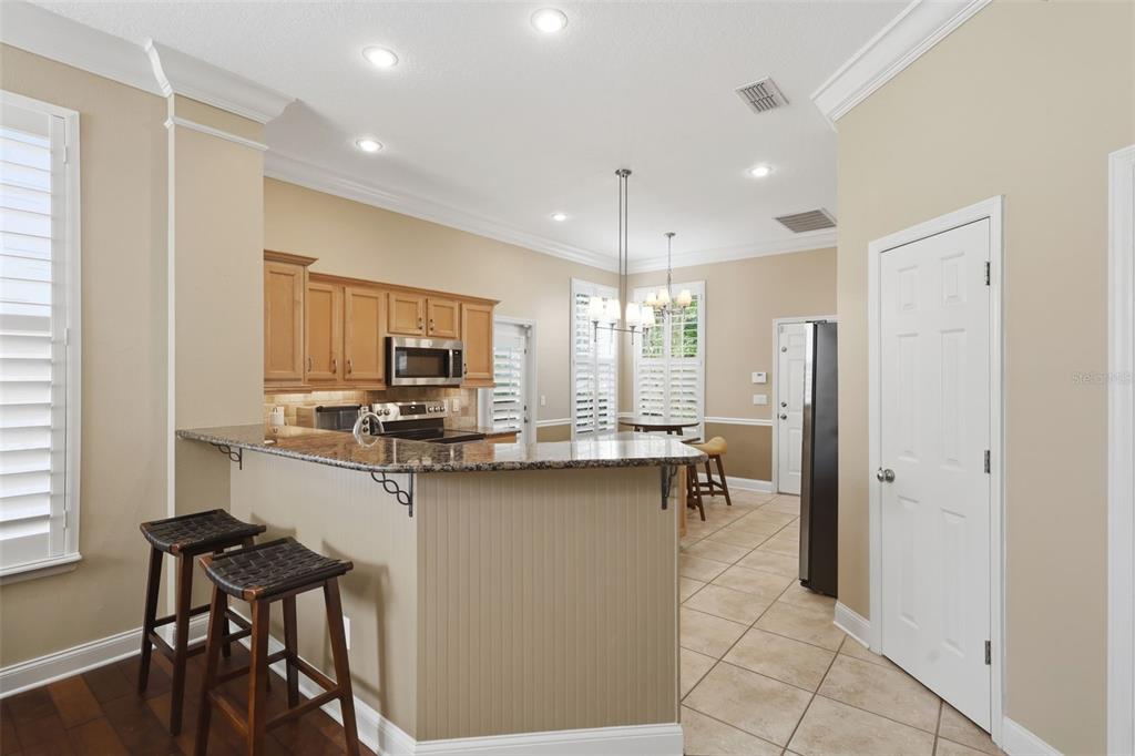 907 Pawstand Road Celebration, FL 34747 - Photo 15 of 49 a kitchen with a table chairs refrigerator and cabinets