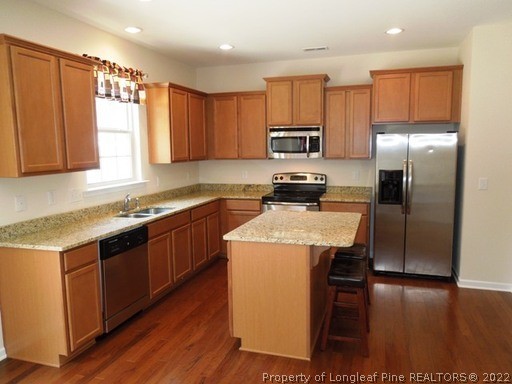 81 River Oak Street Spring Lake, NC 28390 - Photo 6 of 15 a kitchen with a sink a microwave a refrigerator and cabinets