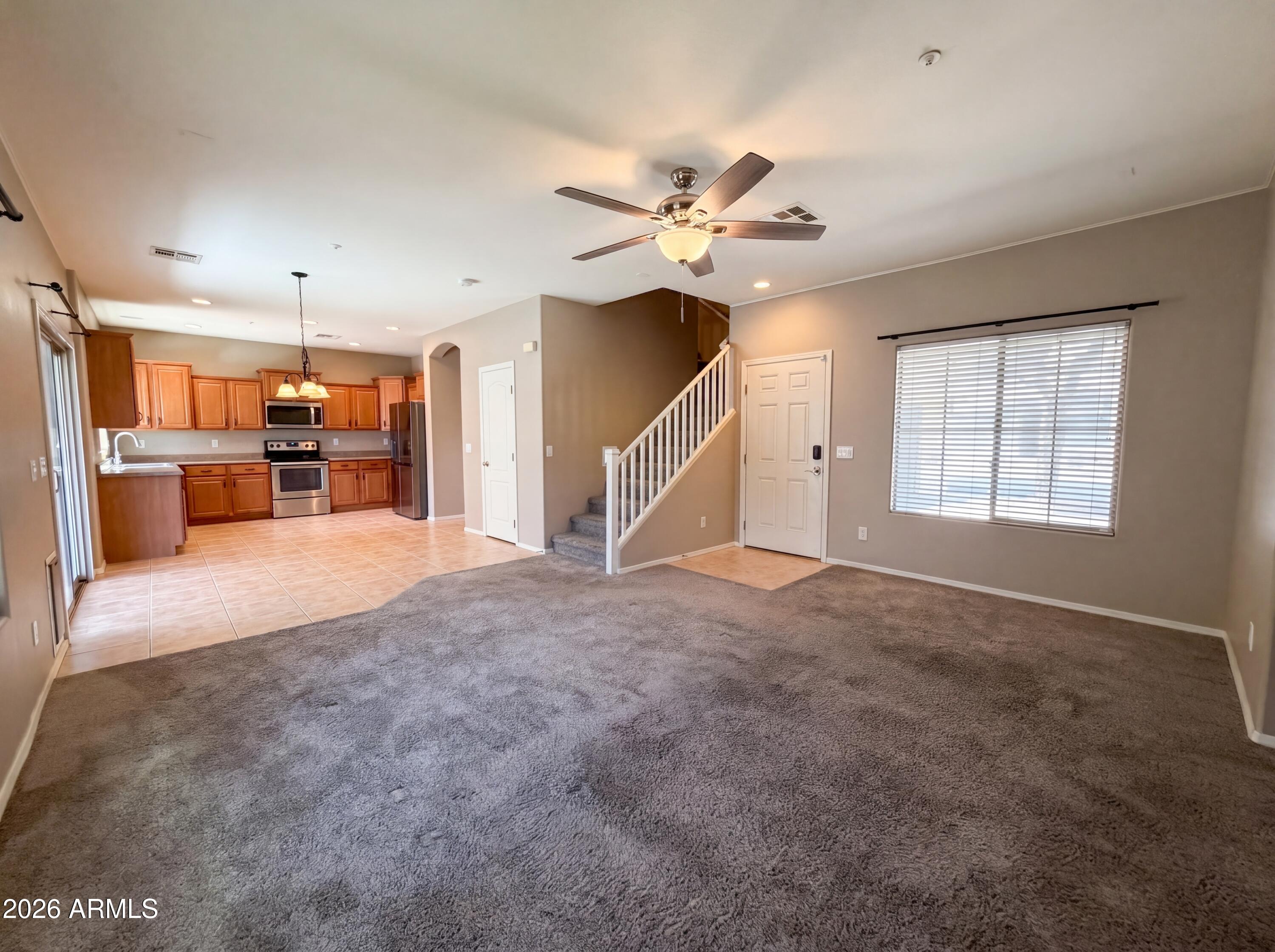 1565 East Hopkins Road Gilbert, AZ 85295 - Photo 3 of 29 a view of a livingroom with a kitchen and a ceiling fan