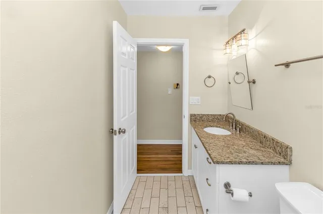 a bathroom with a granite countertop sink and a mirror