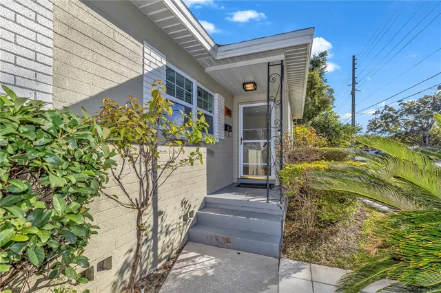 a yellow house with flower garden and a yard