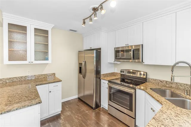 a kitchen with granite countertop a sink and steel appliances
