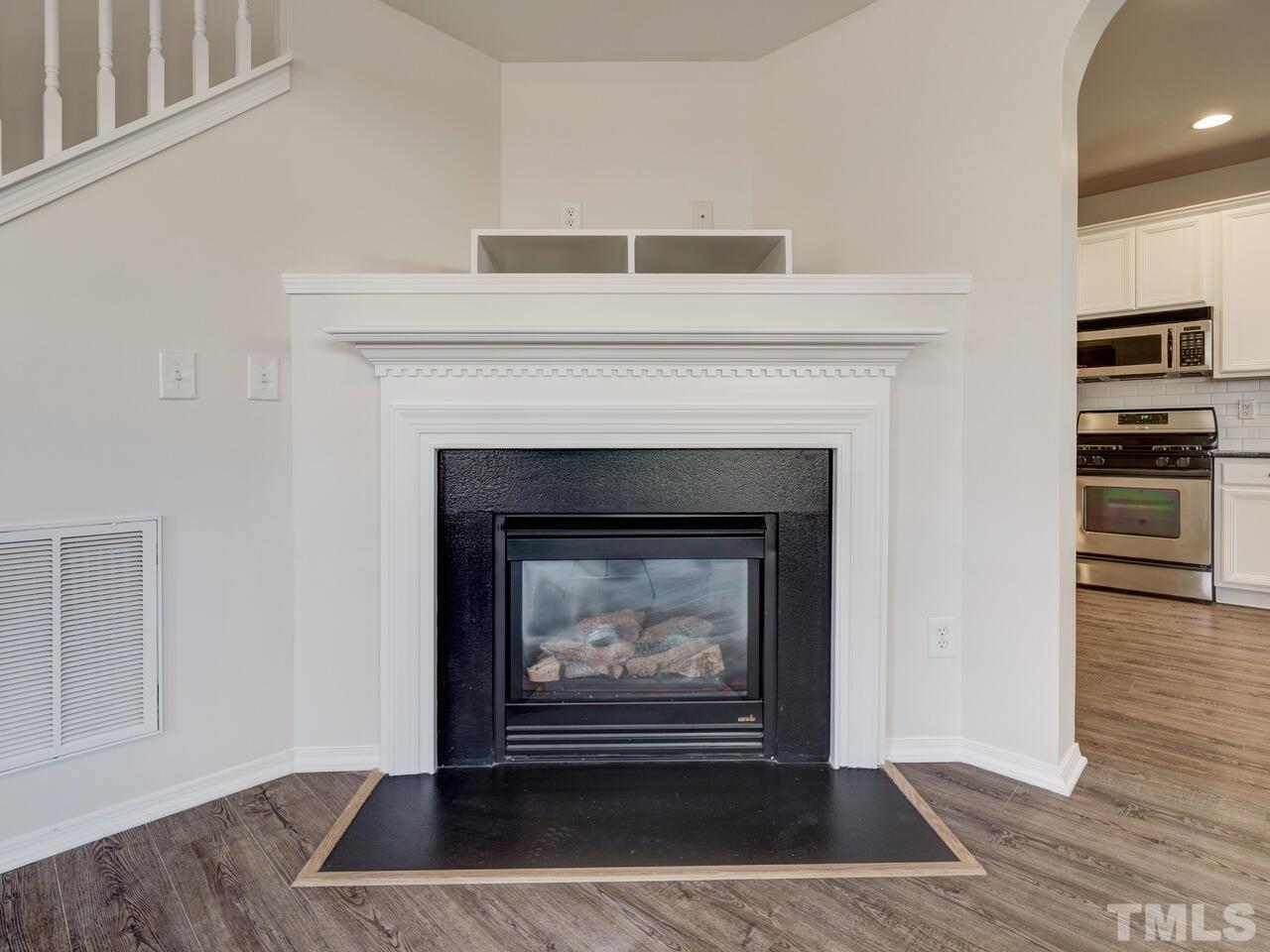 8219 Beaded Stone Street Raleigh, NC 27613 - Photo 14 of 45 a living room with a fireplace