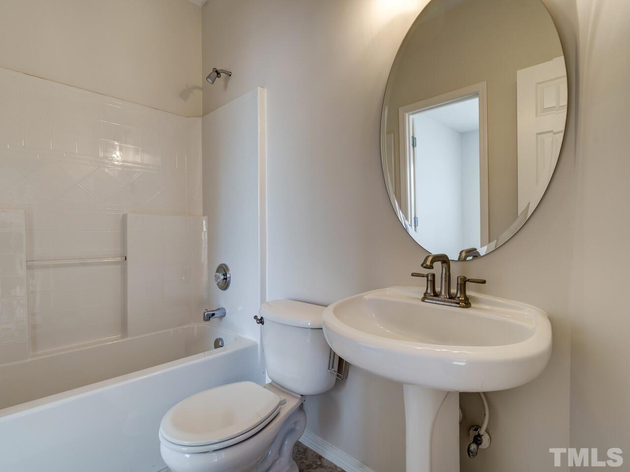 8219 Beaded Stone Street Raleigh, NC 27613 - Photo 16 of 45 a bathroom with a sink a toilet and shower