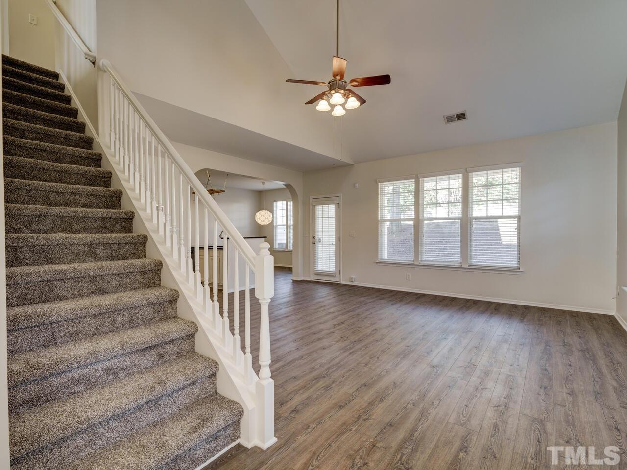 8219 Beaded Stone Street Raleigh, NC 27613 - Photo 20 of 45 a view of staircase with wooden floor and fan