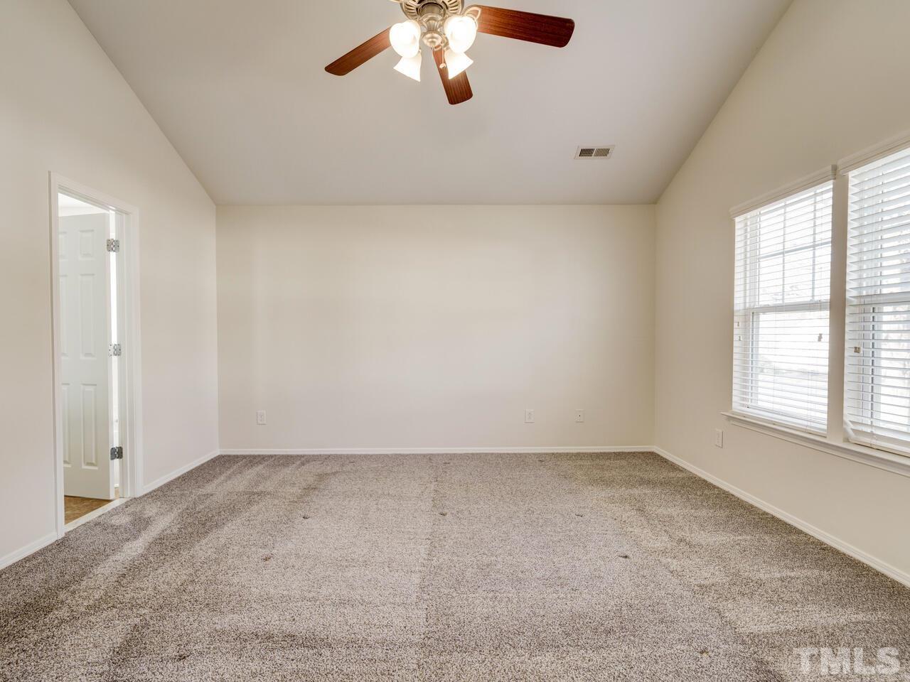 8219 Beaded Stone Street Raleigh, NC 27613 - Photo 22 of 45 an empty room with windows and fan