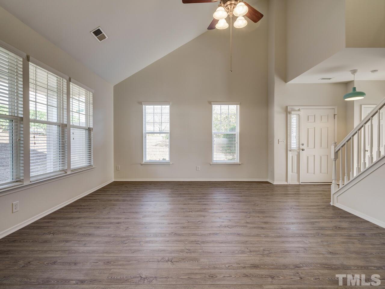 8219 Beaded Stone Street Raleigh, NC 27613 - Photo 3 of 45 a view of an empty room with wooden floor and a window