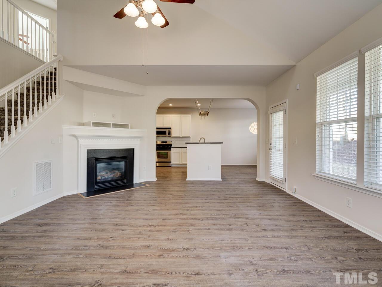 8219 Beaded Stone Street Raleigh, NC 27613 - Photo 4 of 45 wooden floor fireplace and windows in an empty room