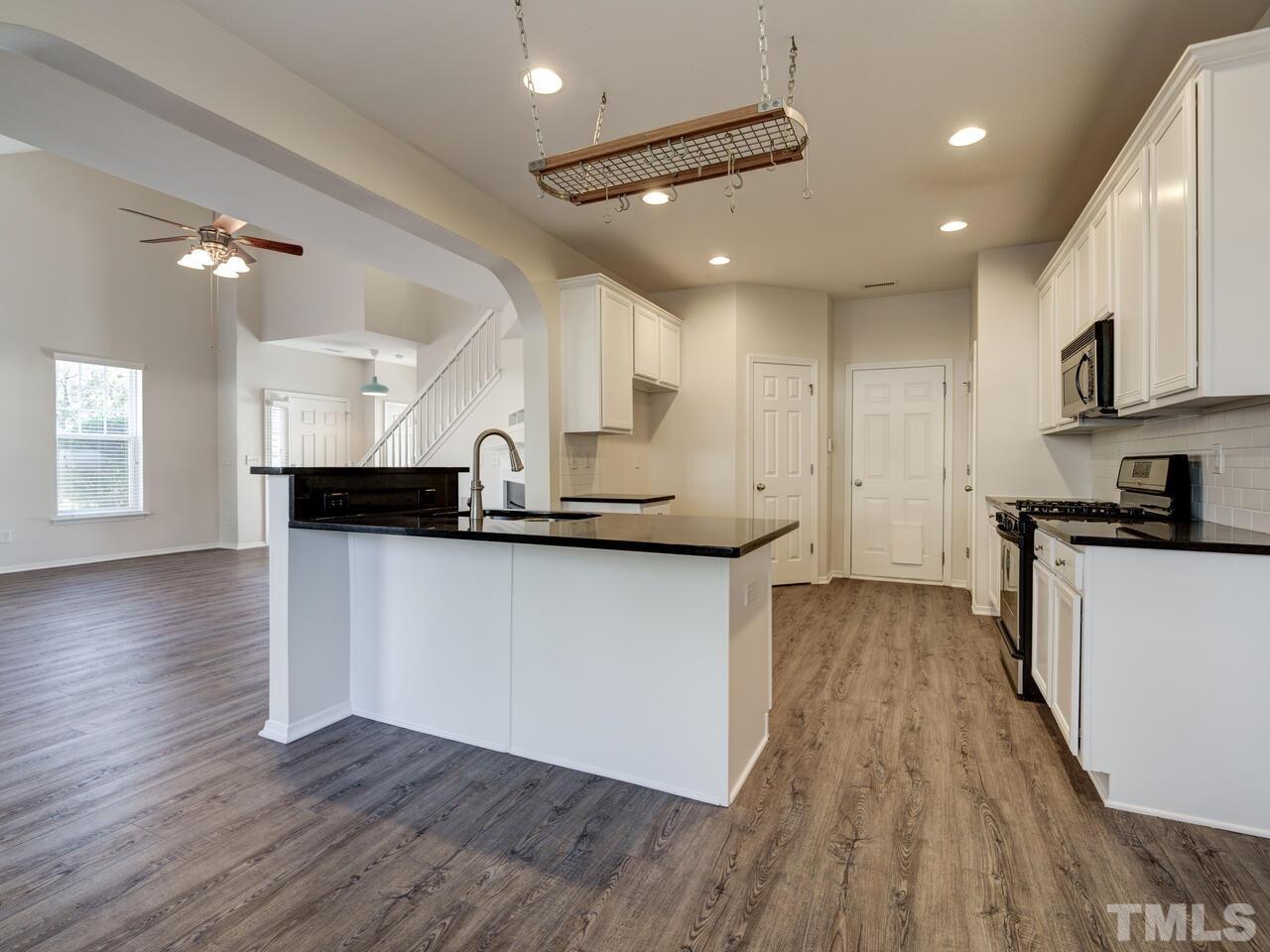 8219 Beaded Stone Street Raleigh, NC 27613 - Photo 8 of 45 a view of kitchen with sink microwave and stove