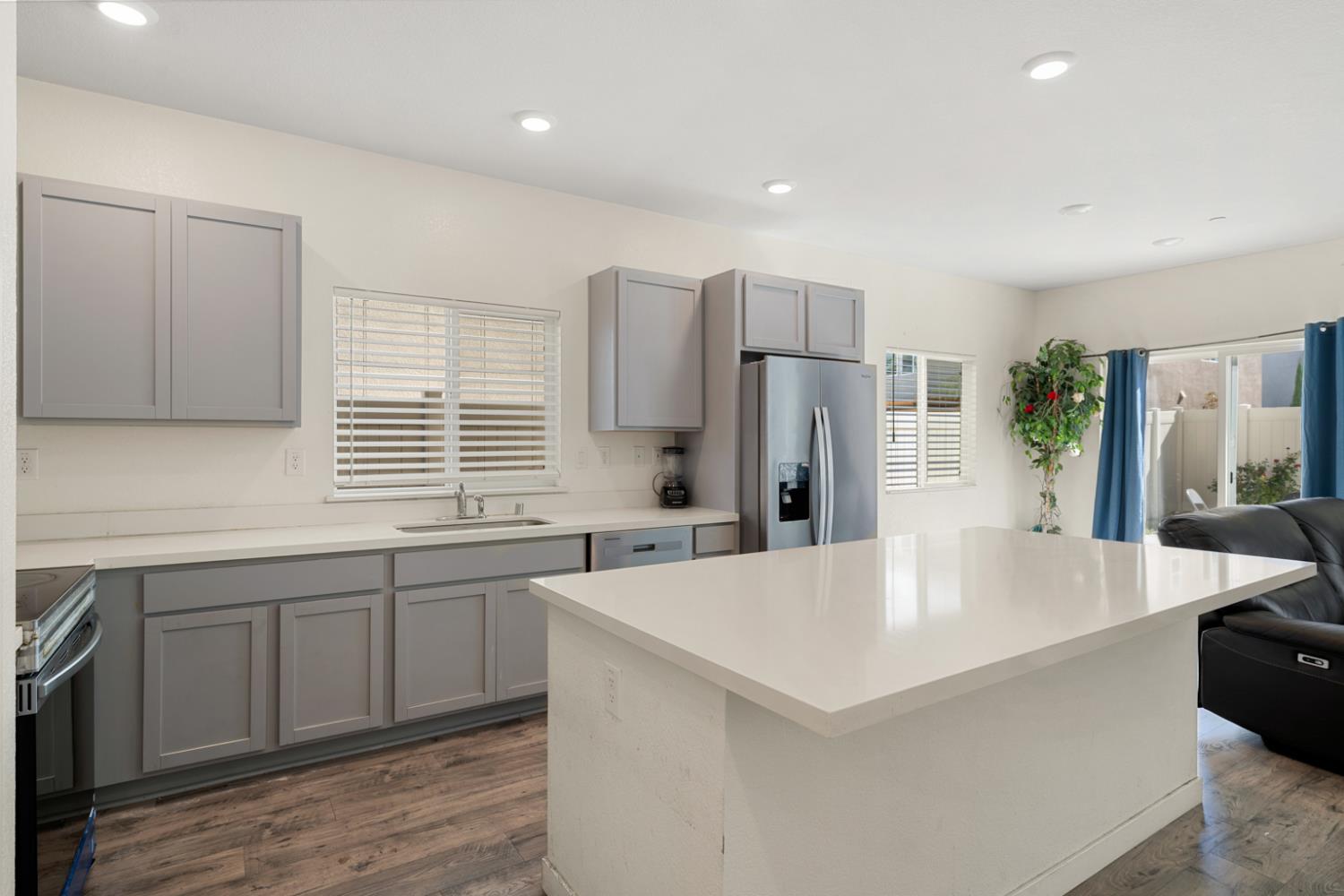 7664 Walpole Way Elk Grove, CA 95758 - Photo 11 of 43 a large kitchen with stainless steel appliances a large counter top a refrigerator and a sink