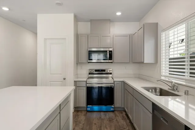 a kitchen with stainless steel appliances a refrigerator sink and stove