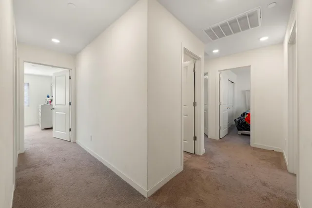 a large kitchen with stainless steel appliances a large counter top a refrigerator and a sink