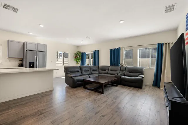 a living room with furniture and a wooden floor