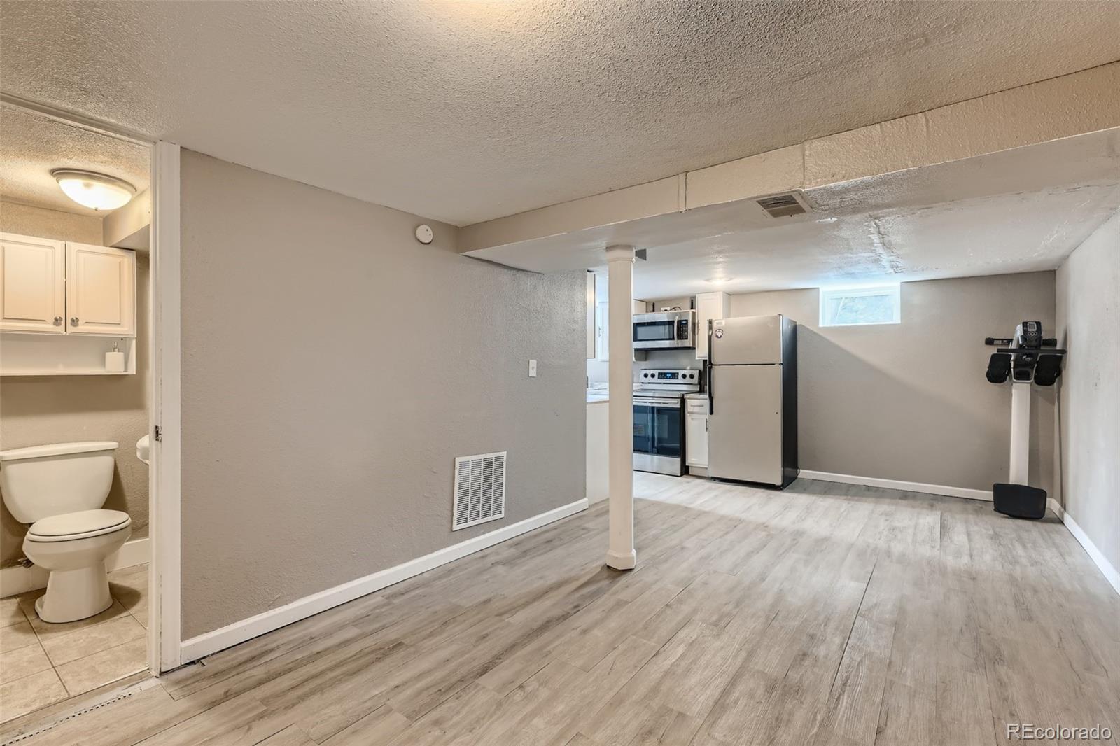 44 Julian Street Denver, CO 80219 - Photo 15 of 26 a view of an empty room and wooden floor