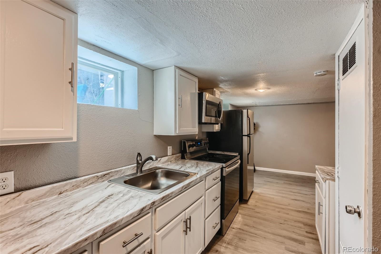 44 Julian Street Denver, CO 80219 - Photo 17 of 26 a kitchen that has a sink and a stove in it