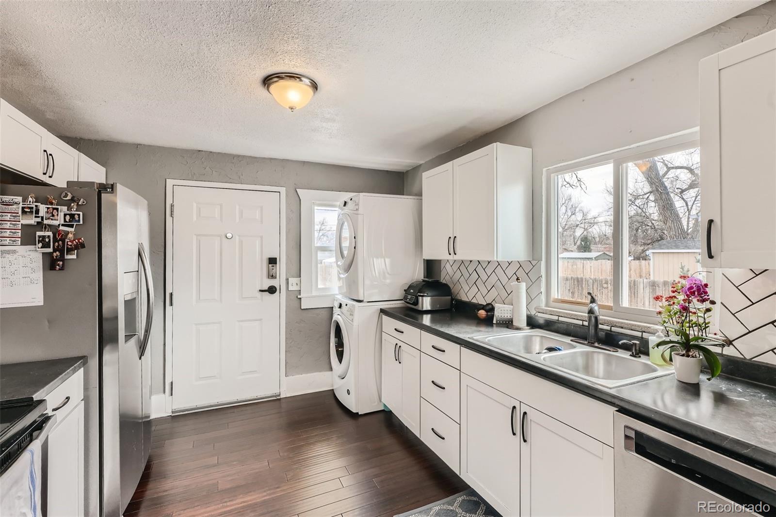 44 Julian Street Denver, CO 80219 - Photo 6 of 26 a kitchen with stainless steel appliances granite countertop a sink and a refrigerator