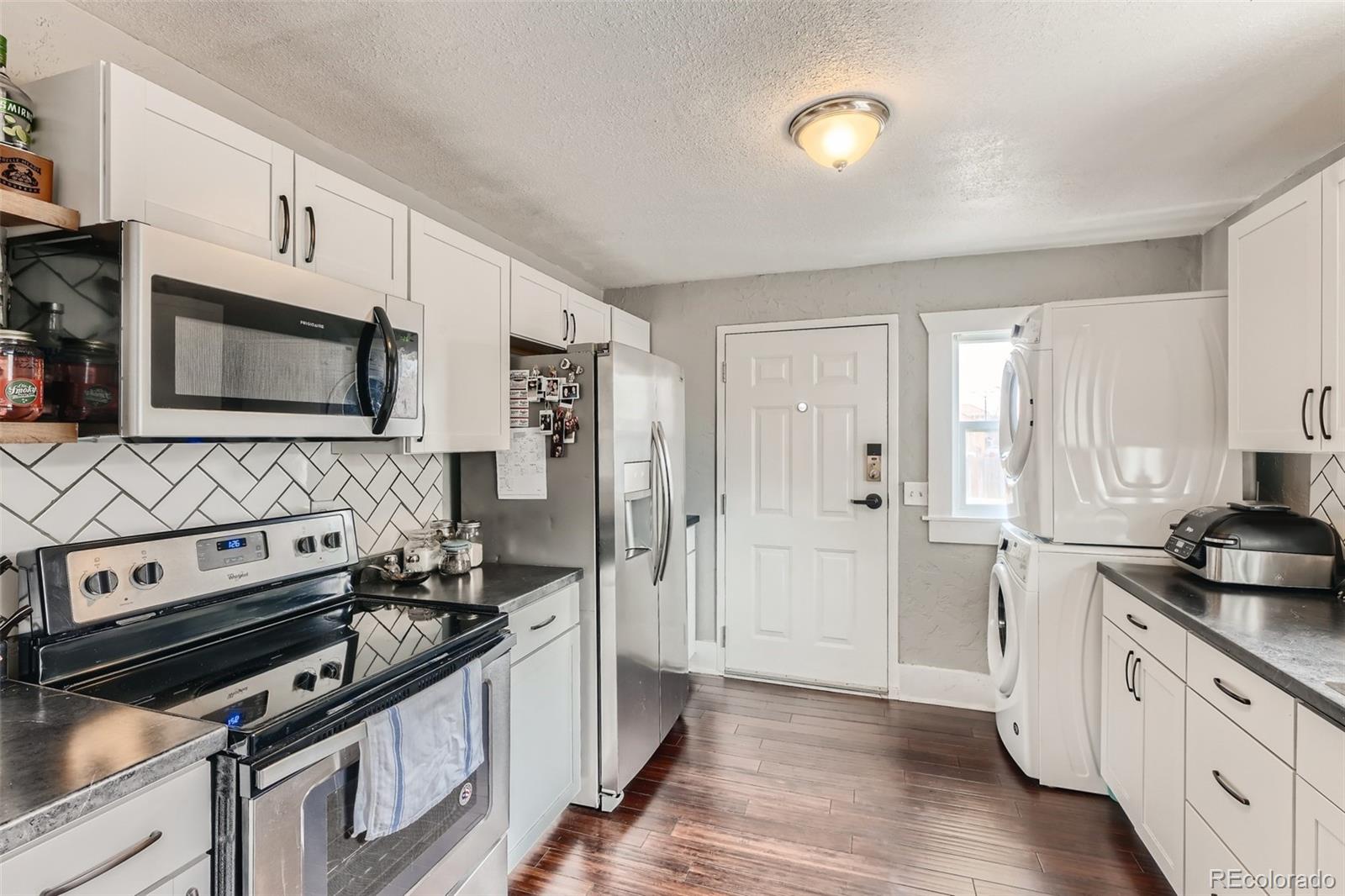 44 Julian Street Denver, CO 80219 - Photo 7 of 26 a kitchen with stainless steel appliances a stove a sink and a refrigerator