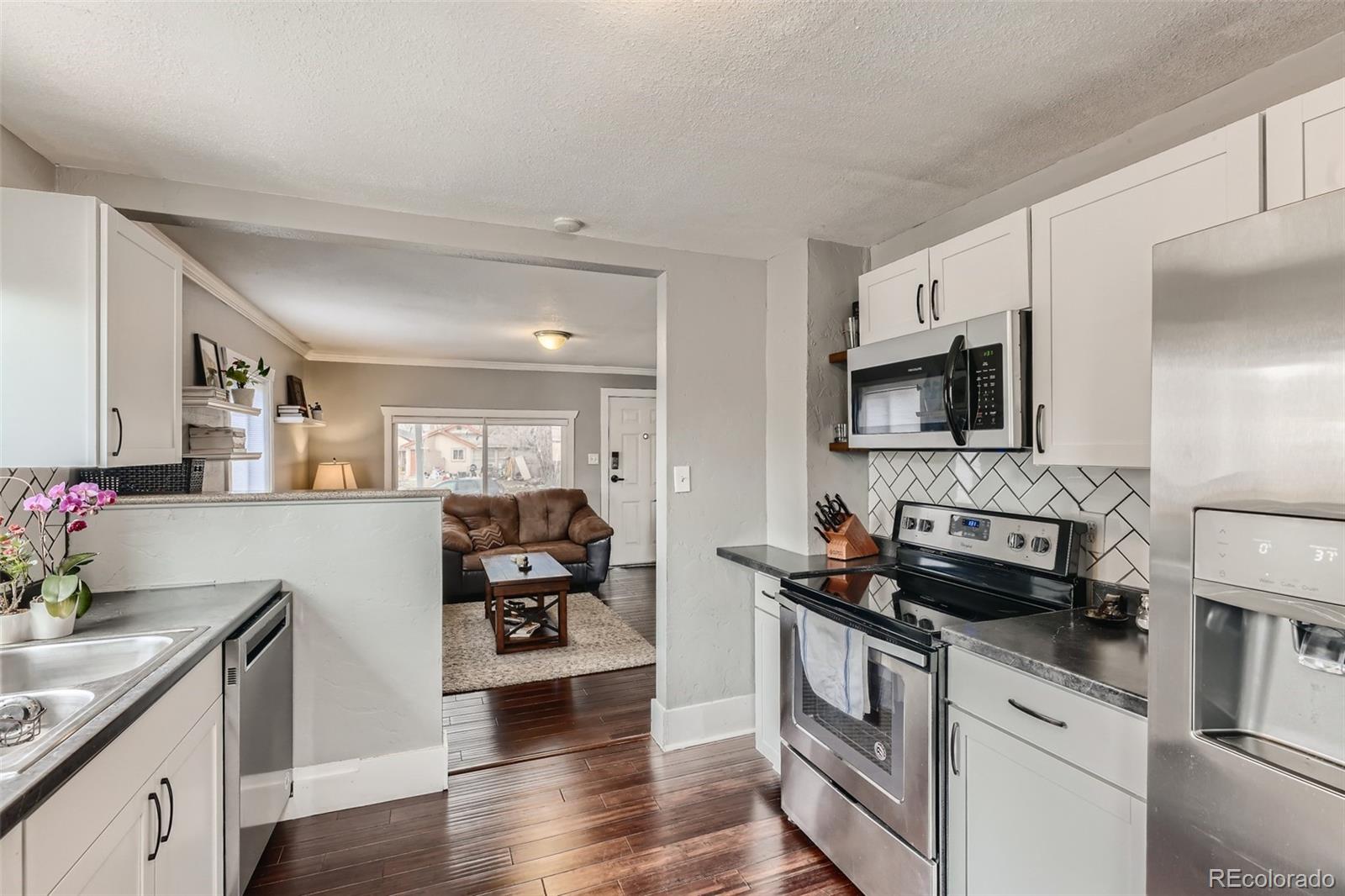 44 Julian Street Denver, CO 80219 - Photo 9 of 26 a kitchen with a sink and a stove top oven