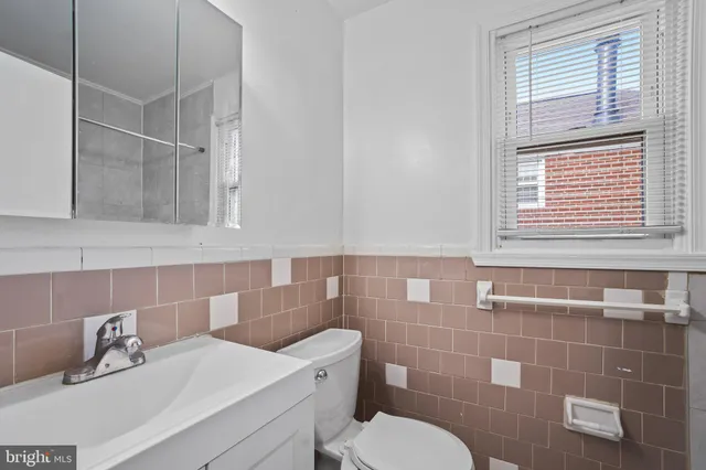 a bathroom with a sink a toilet and a mirror