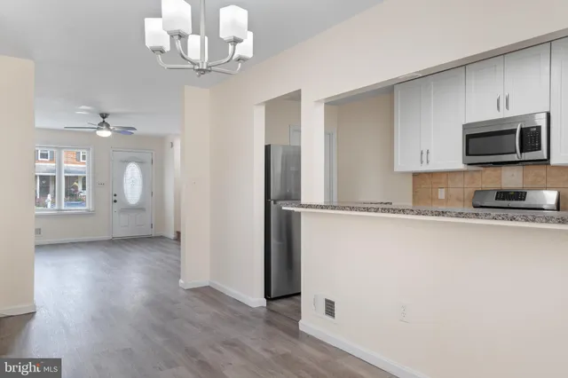 a kitchen with granite countertop a refrigerator and a stove top oven