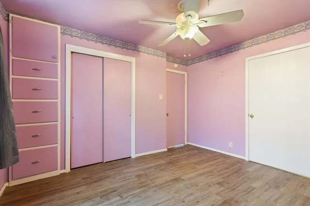 wooden floor in an empty room with a chandelier fan